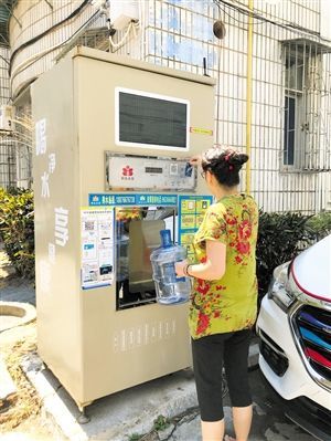 5月24日，瓊山區(qū)上丹花苑小區(qū)居民陳女士在使用共享凈水機(jī)取水。 本報(bào)記者 陳歆卓 攝